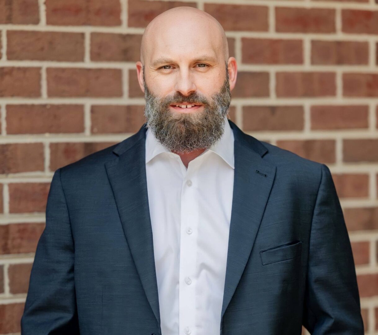 A bald man with a beard wearing a suit and tie.